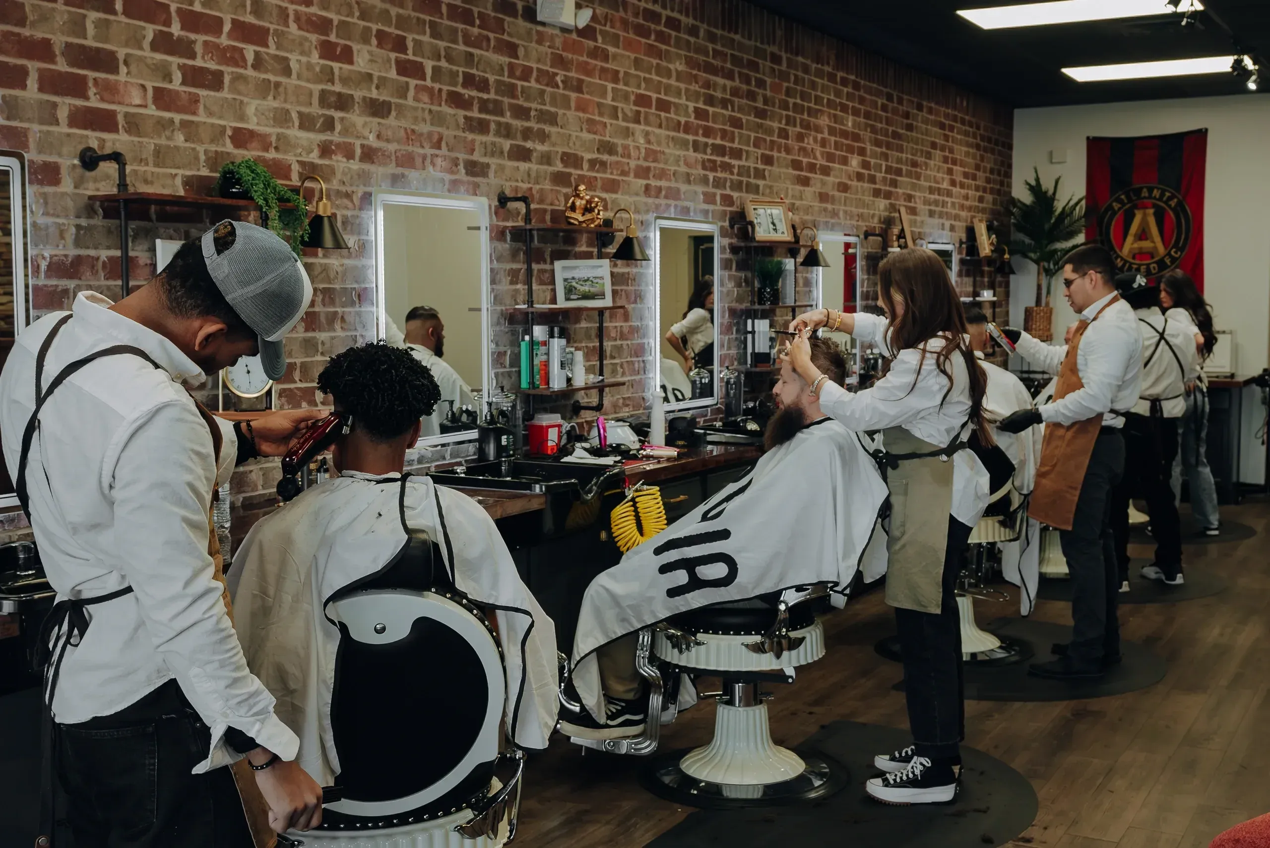 A barber finishing a cut at the chair