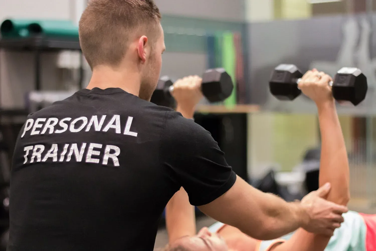 A personal trainer coaching a client through a lift
